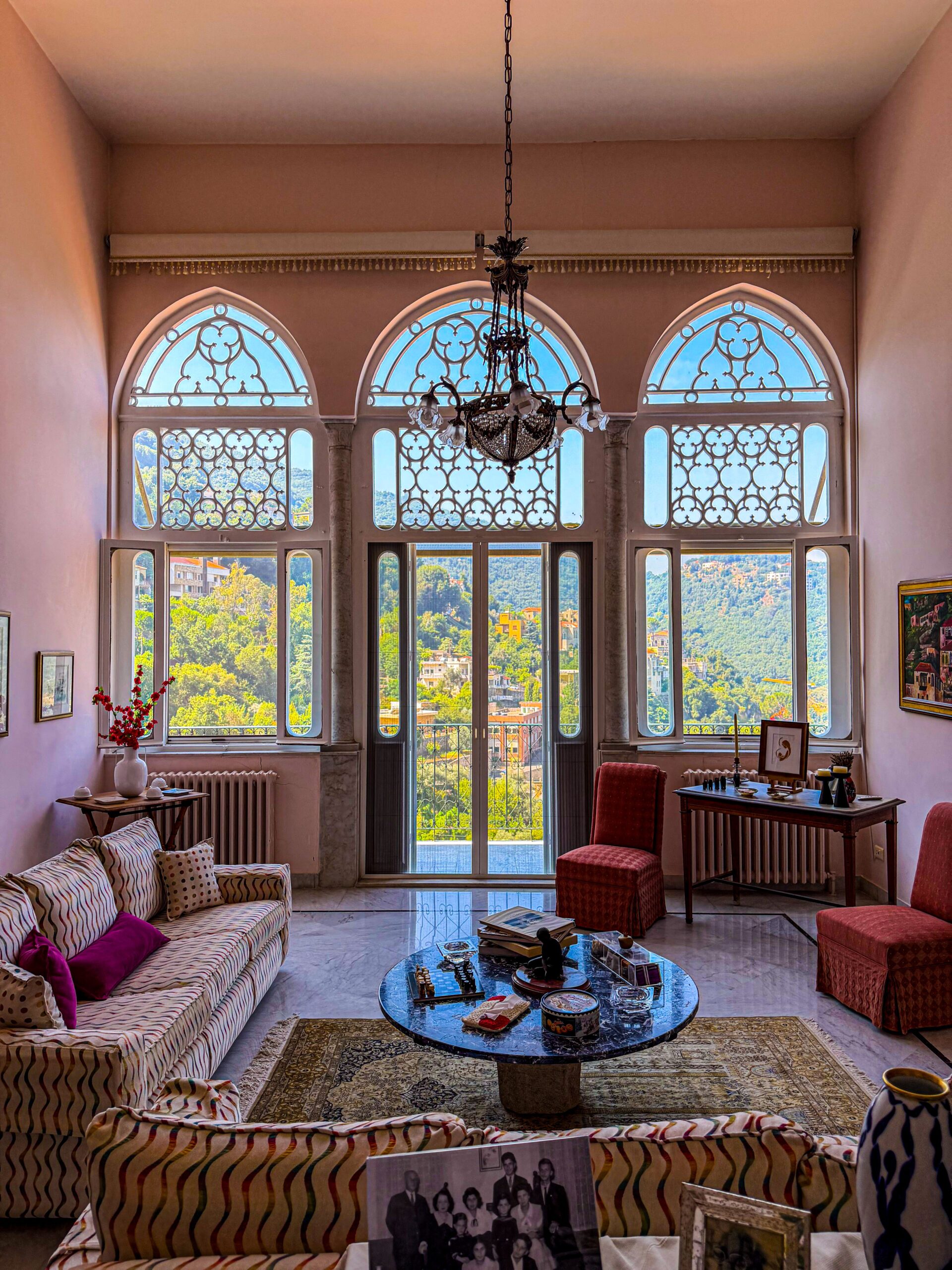 Elegant European living room with arched windows, vintage furniture and natural light
